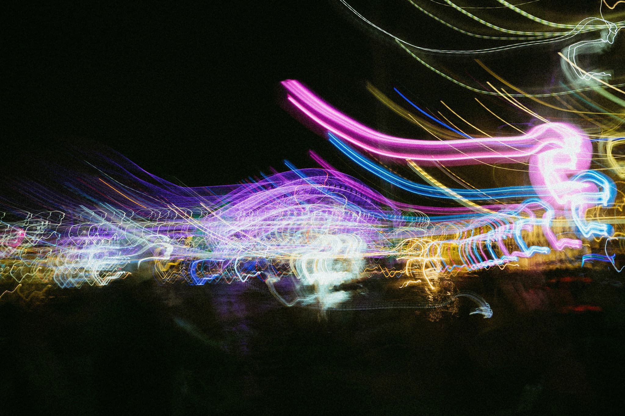 A colorful, abstract display of blurred lights against a dark background, creating a dynamic and vibrant effect