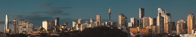 A city skyline with numerous modern skyscrapers under a clear blue sky